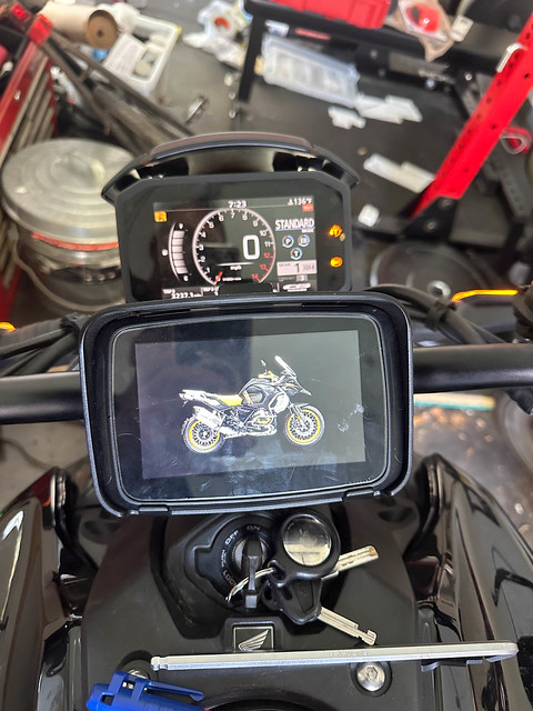 The speedometer and the CarPlay unit are both lit up. The CarPlay unit is showing an image of a motorcycle.