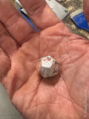 A copper dodecahedron with uneven silver solder all over it. You can see gaps and protruding parts of the joints