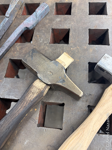 A charred hickory handle in the hardened hammer head